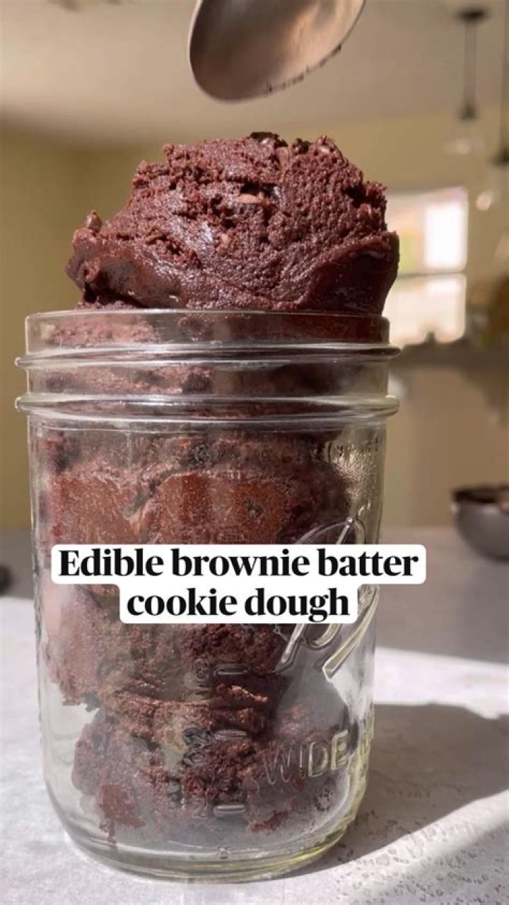 Cookie dough (brown batter, flour, oats) in a large glass bowl.