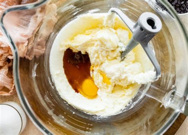 Cookie dough (eggs, butter, sugar, molasses) in a large glass bowl.