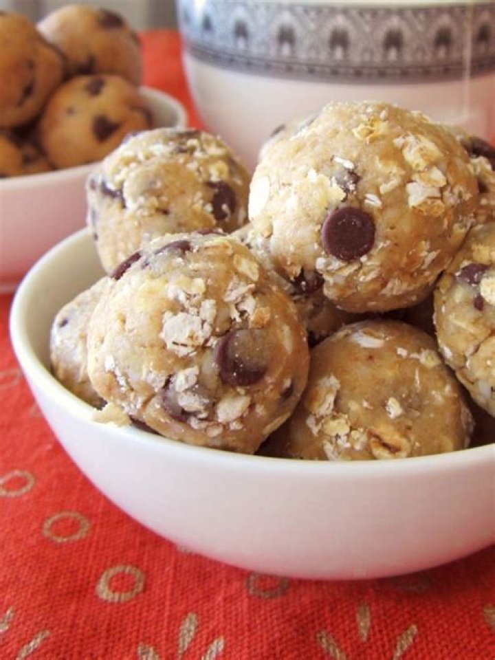 Oatmeal cookie dough balls on a parchment lined baking sheet.