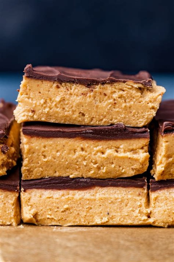 Stack of three peanut butter rice krispies treats topped with chocolate frosting.