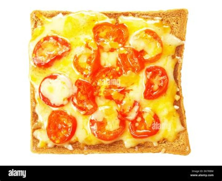 Toast with melted cheese and a salad on a white plate.